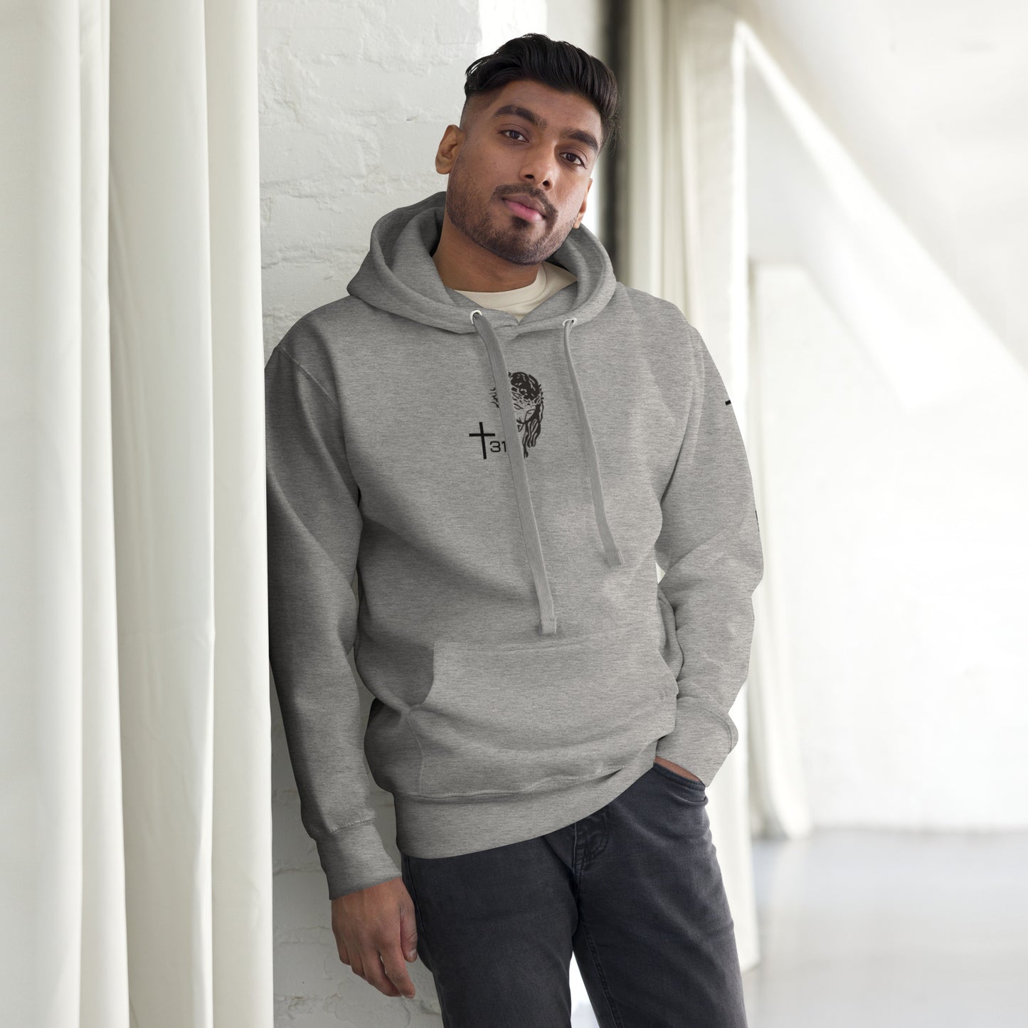 A man in a grey hoodie and jeans, showcasing the unisex-premium-hoodie-carbon-grey-front style.