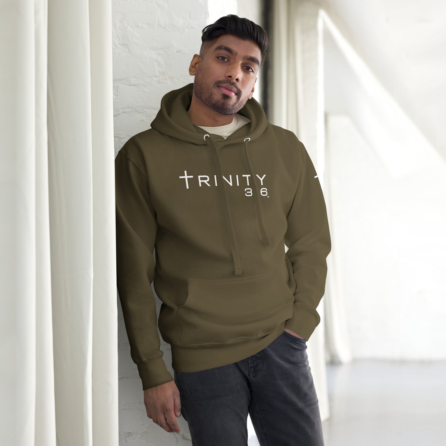 A man in a military green unisex premium hoodie featuring the word Trinity 316 prominently displayed on the front.