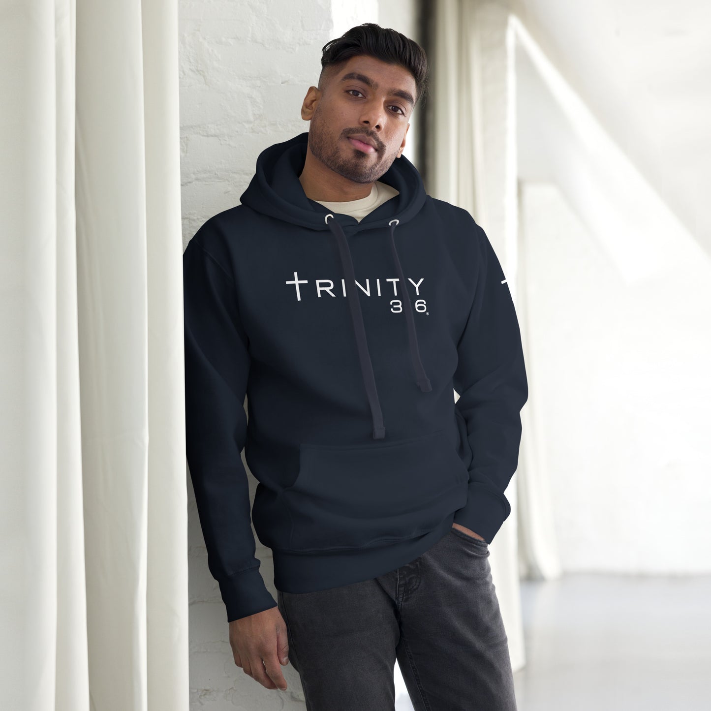 A man models a unisex premium hoodie in navy blazer, showcasing its stylish front design and comfortable fit.