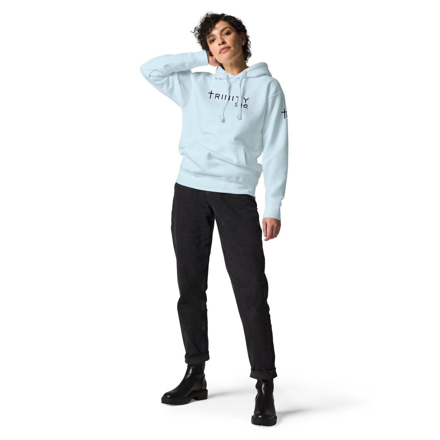 A woman dressed in a sky blue unisex premium hoodie and black pants, showcasing a casual and stylish look.