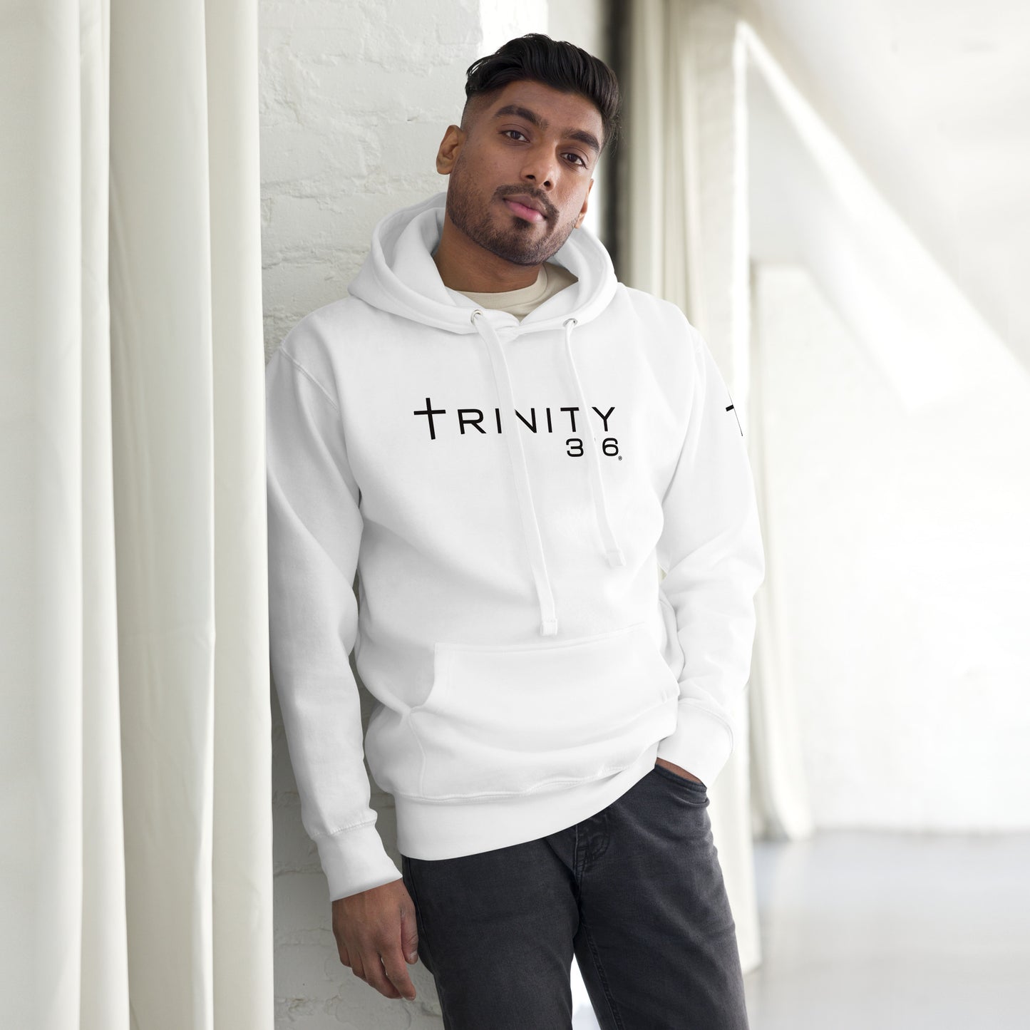 A man models a unisex premium white hoodie, showcasing its stylish front design and comfortable fit.