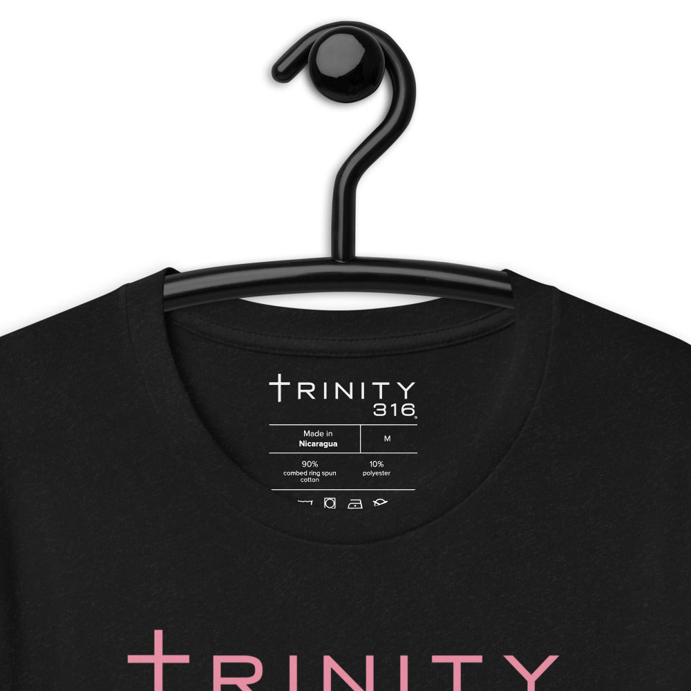 Close-up of a black t-shirt displaying "trinity" in vibrant pink lettering, perfect for casual wear.