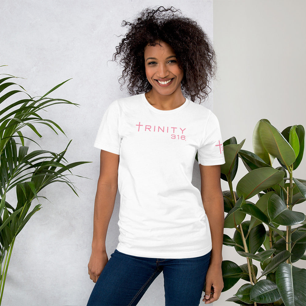 A woman models a unisex staple t-shirt in white, showcasing the Trinity Life logo on the front.