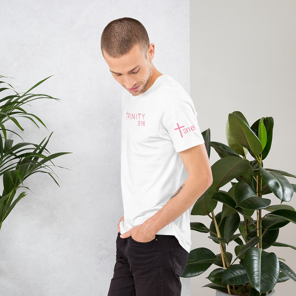 A man in a white unisex staple t-shirt with pink lettering, showcasing a casual and stylish look.
